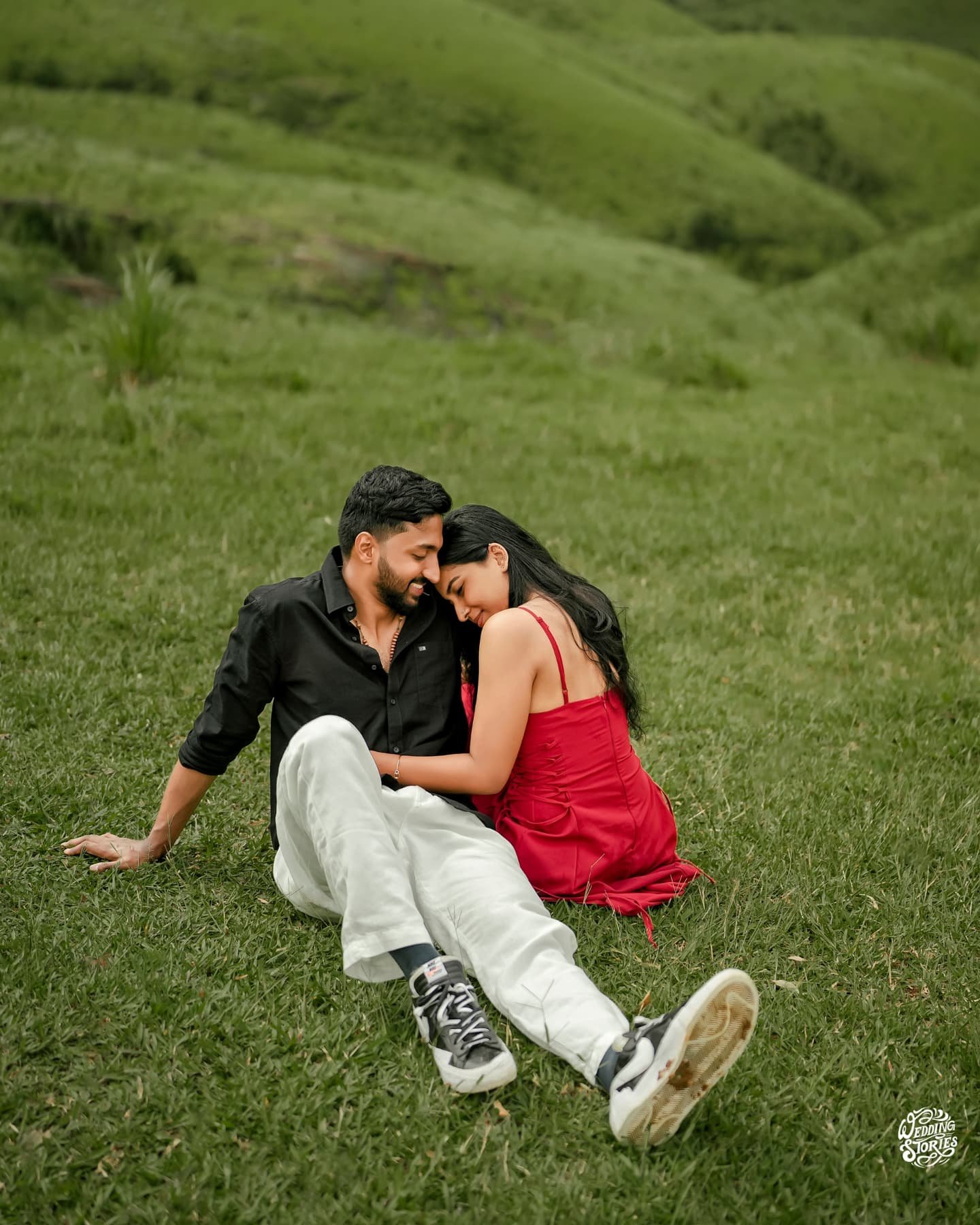 A couple relaxing together on a green hillside